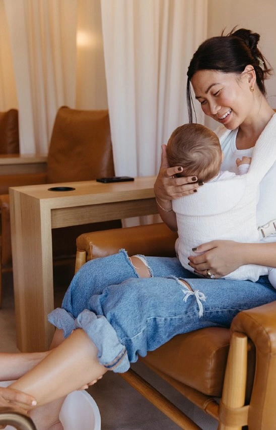 A mom holds her baby during a pedicure at The Lullabar